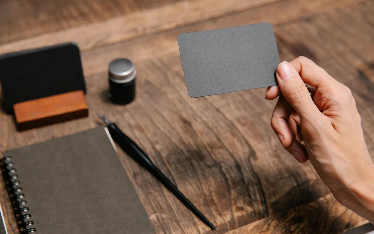 A hand holding a finished printed business card