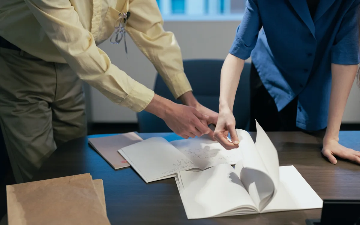 Hands holding a printed proof, checking it before approval